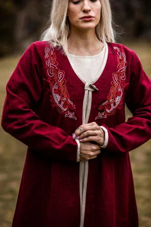 Historiallinen pukeutuminen Keskiaikafestivaalilla: nainen upeassa kirjaillussa keskiaikaisessa asussa luonnon helmassa.